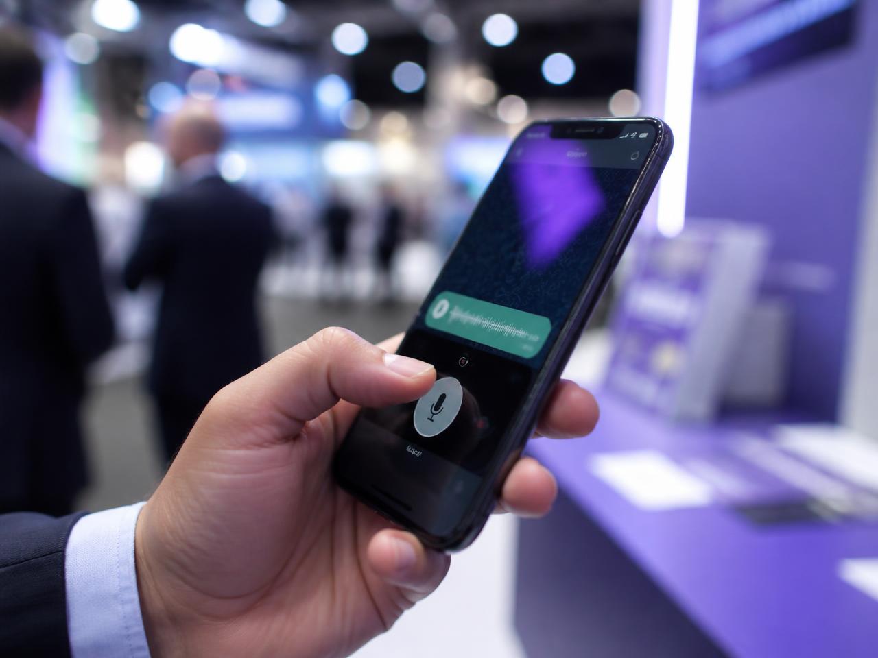 Vendedor gravando um áudio no WhatsApp durante um evento